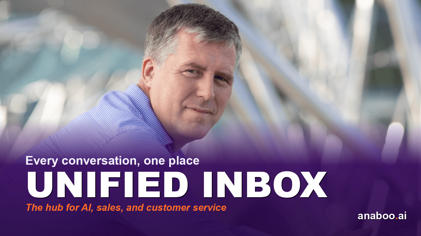 Business owner at a desk reviewing a single screen showing email, SMS, and chat messages from multiple customers in one organised timeline
